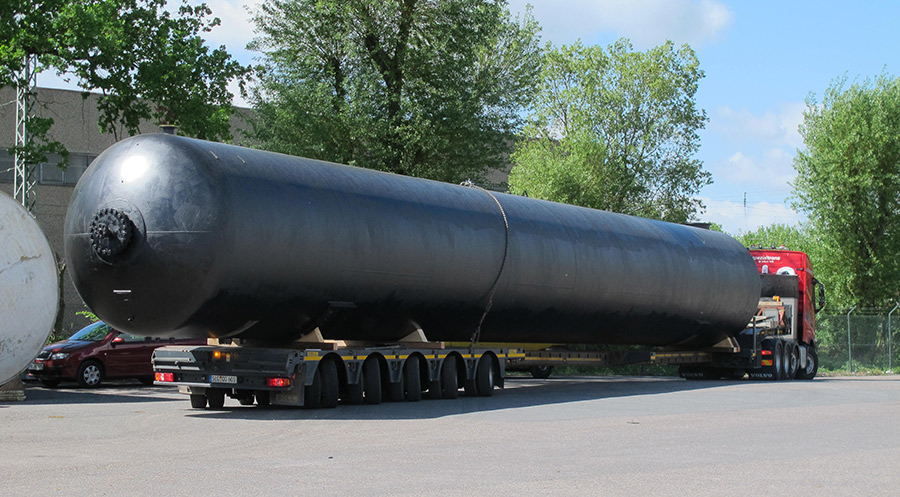 auf Tiefbett liegender, schwarzer unterirdischer Regenwasser Lagerbeh&auml;lter mit 170.000 Liter Volumen; Fahrzeug verl&auml;sst Lagerplatz der Firma Tank und Apparate Barth GmbH